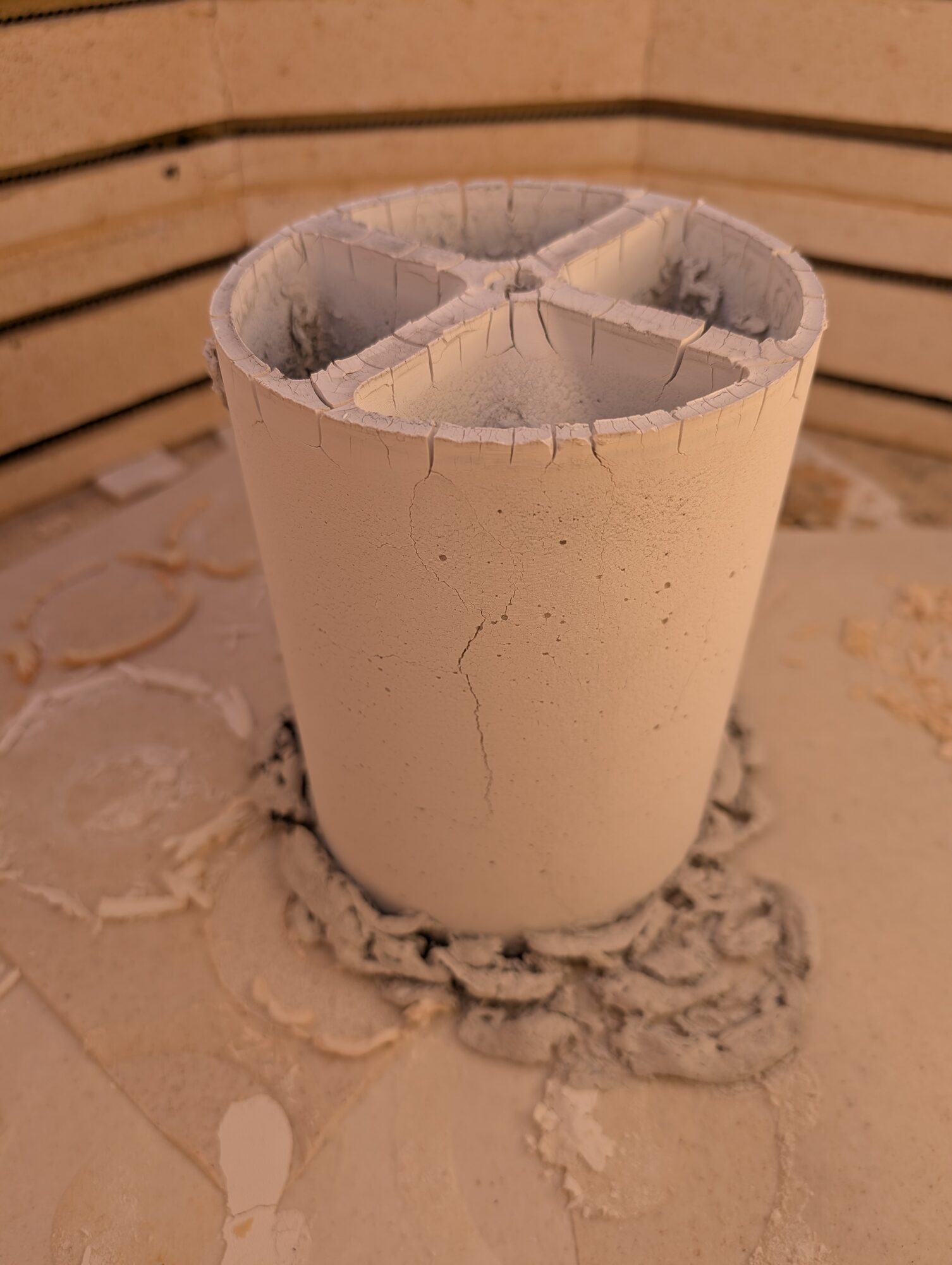 A cast part in the kiln, cracked around the rim and down one side