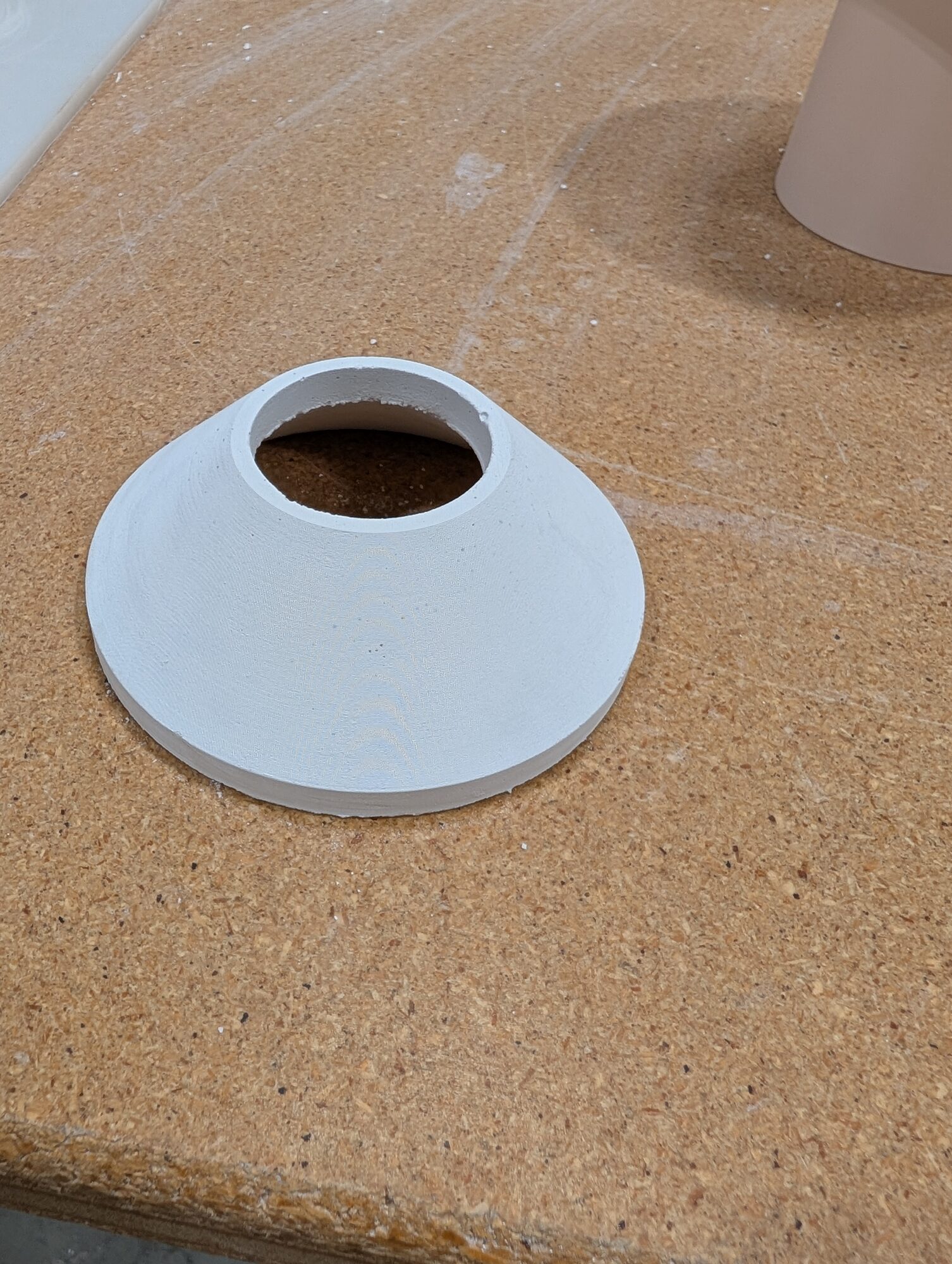 A white cast alumina cone with a bored center