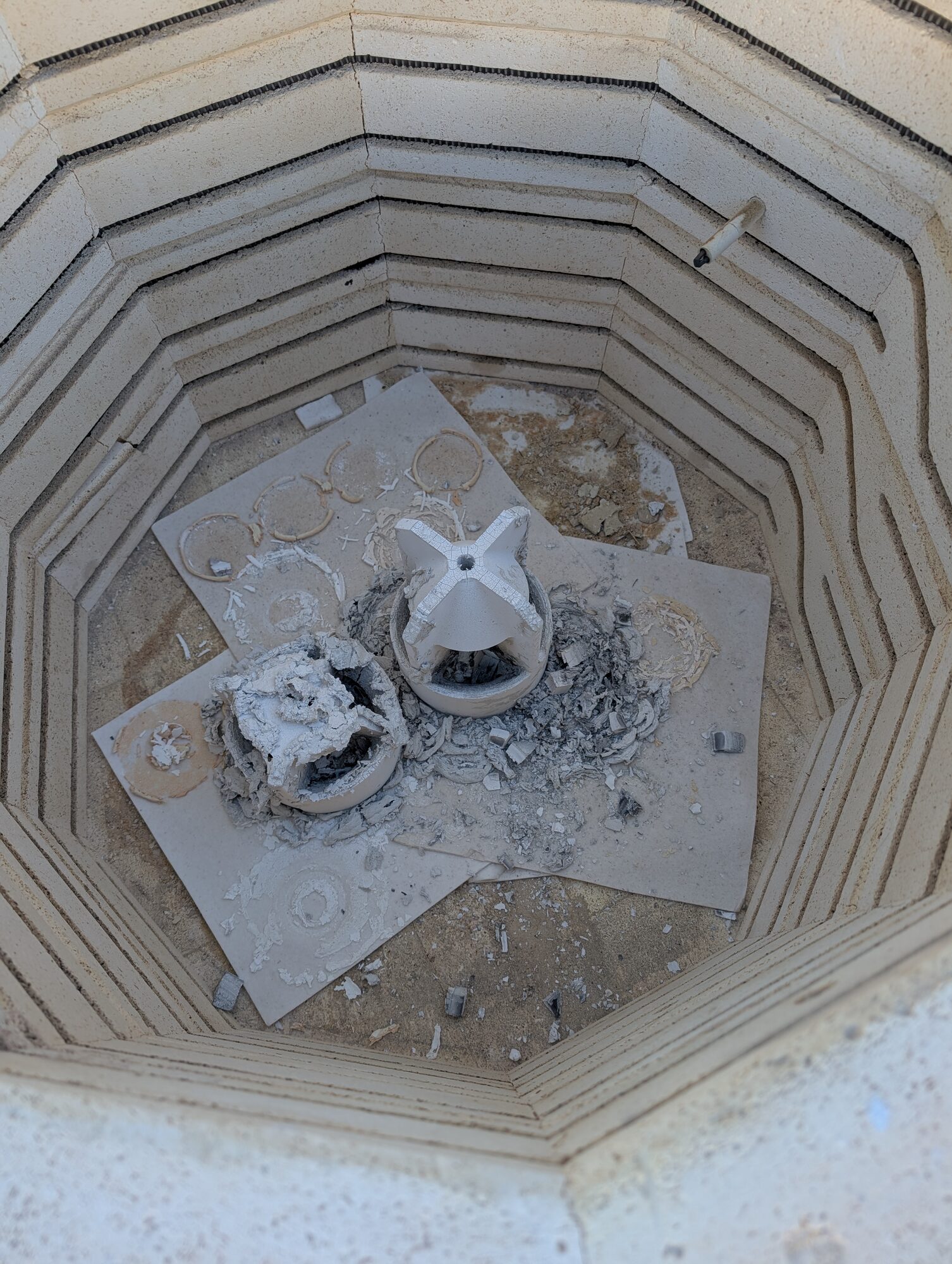 Kiln shelf with broken shell pieces and ash