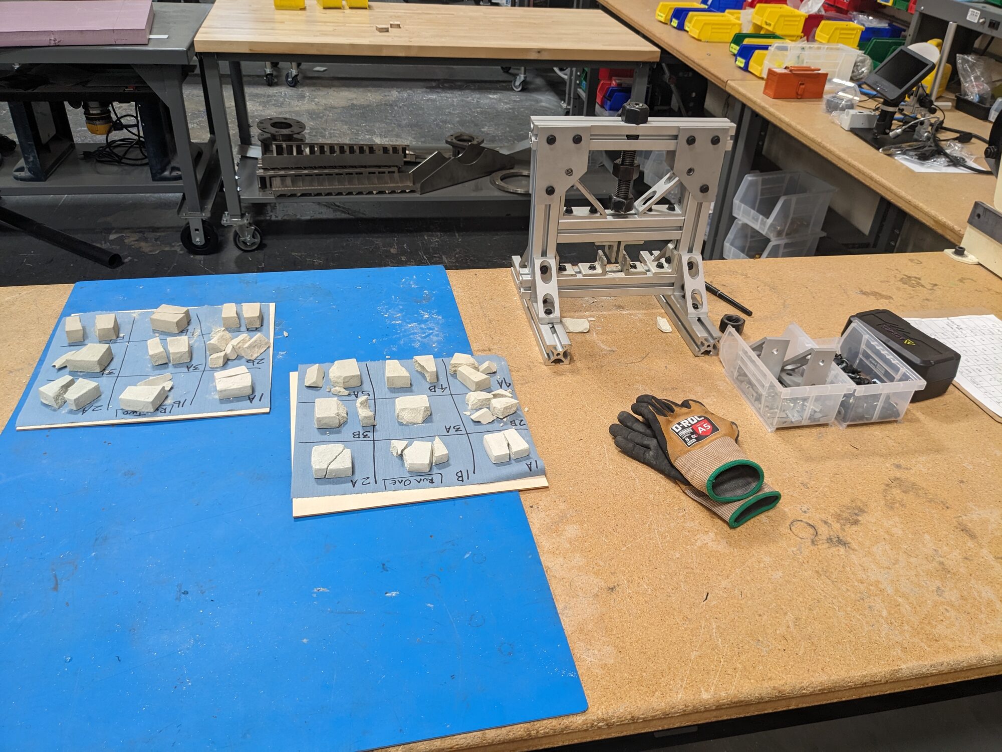 Crushed tiles beside the compression test rig on the bench