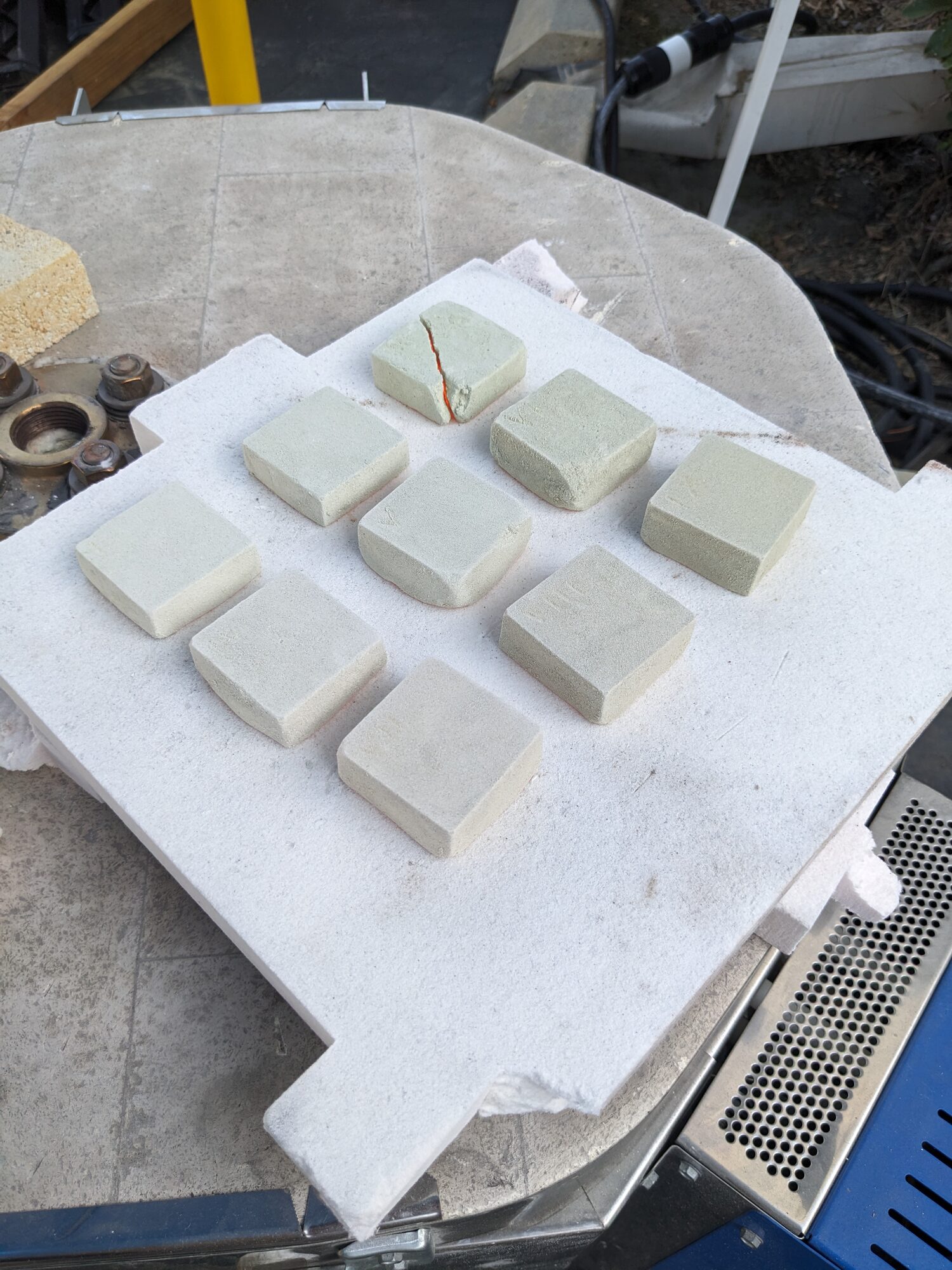 Tiles laid out on a kiln shelf before firing