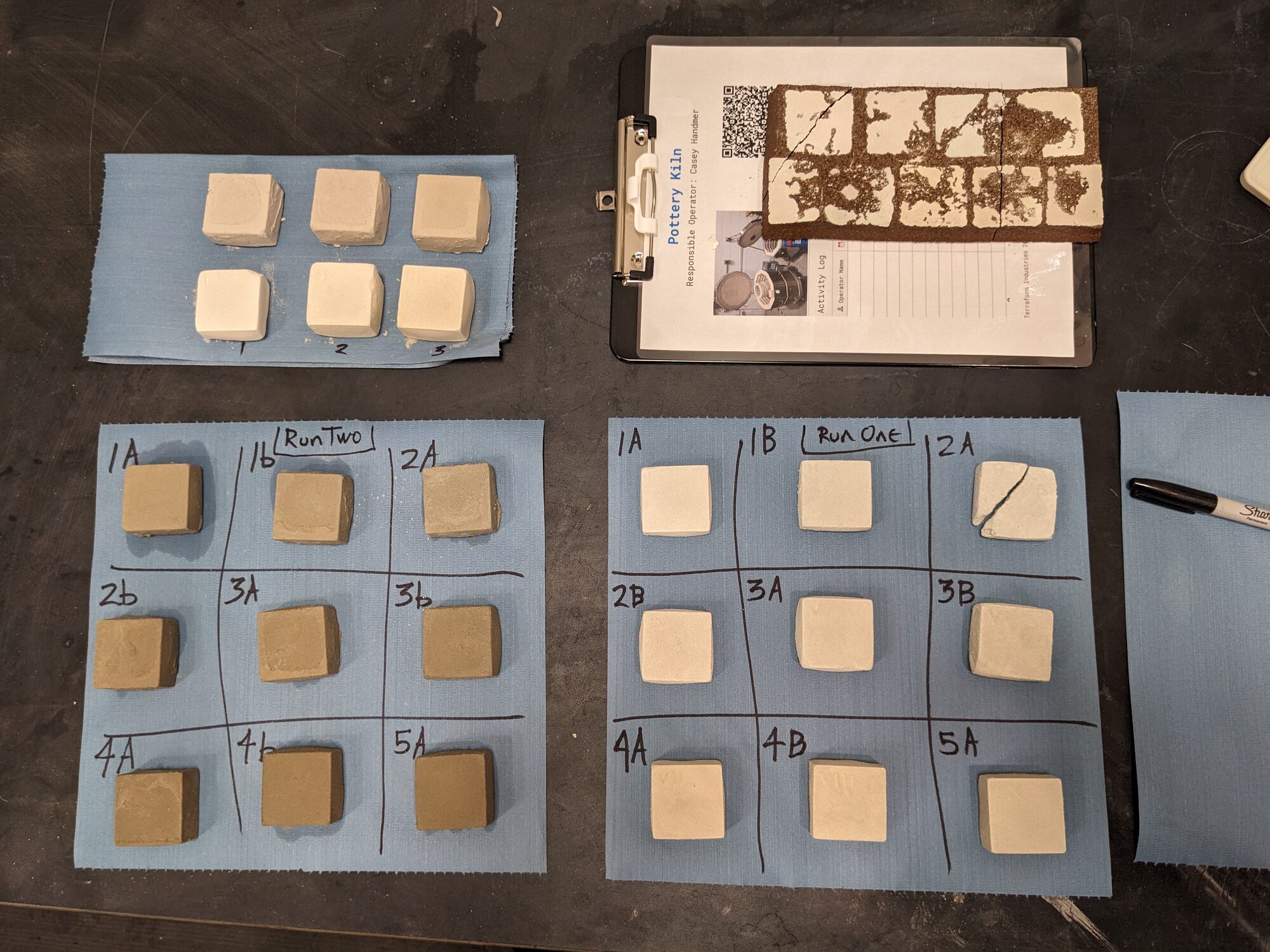 Two grids of small cast refractory tiles labelled Run One and Run Two on blue mats