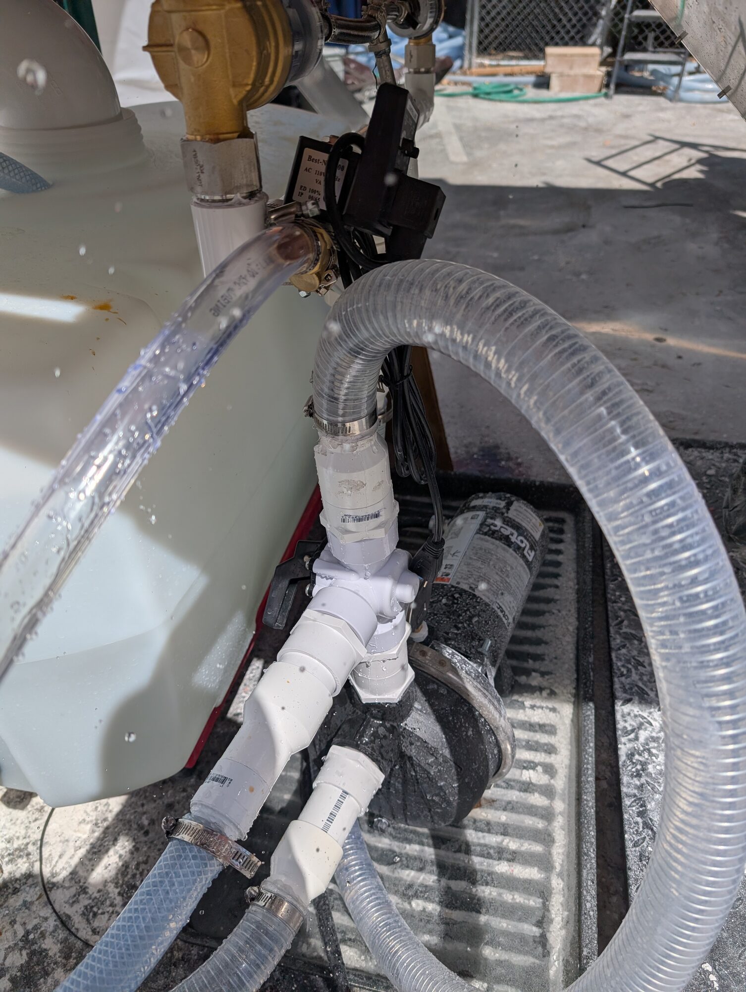 Water flowing through clear hoses at the tank and pump during an early wet test