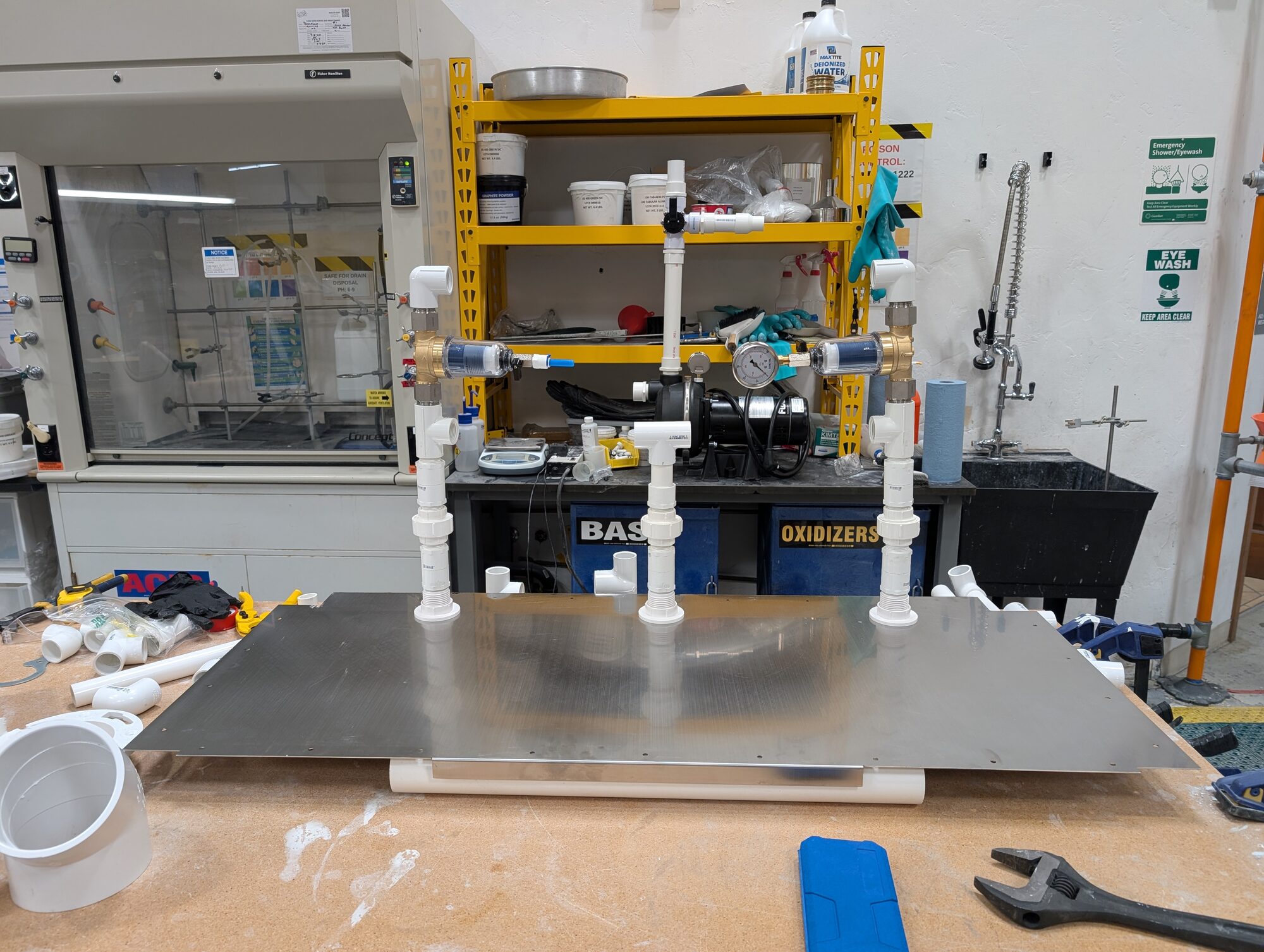 The PVC manifold standing on a stainless sheet in the lab, filters and gauge mounted, pump behind