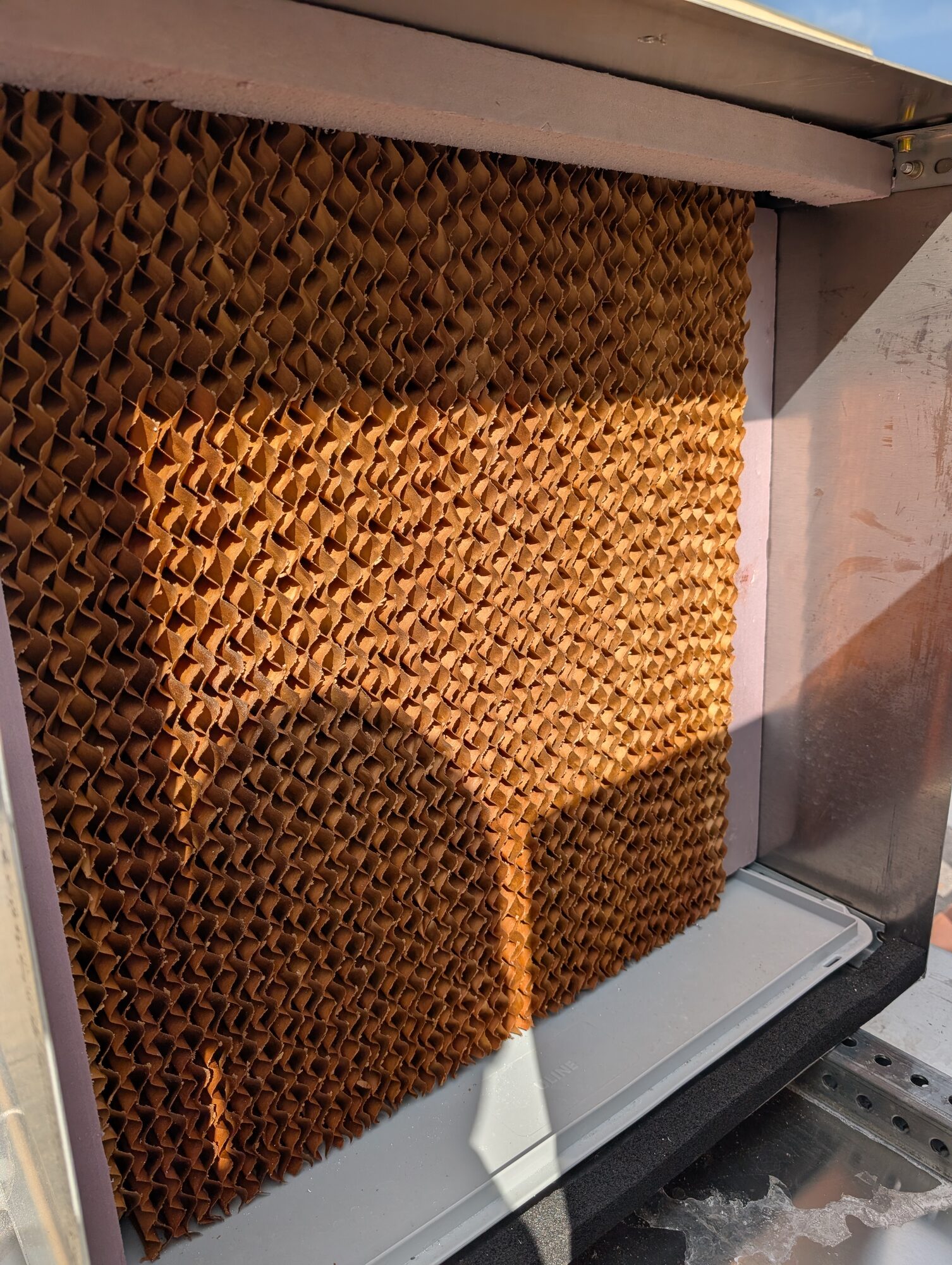 A block of brown corrugated cellulose evaporative media filling the test section