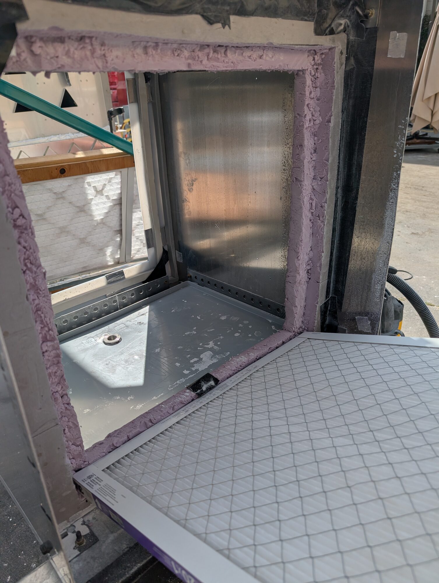A pleated white panel filter resting against its foam-gasketed frame