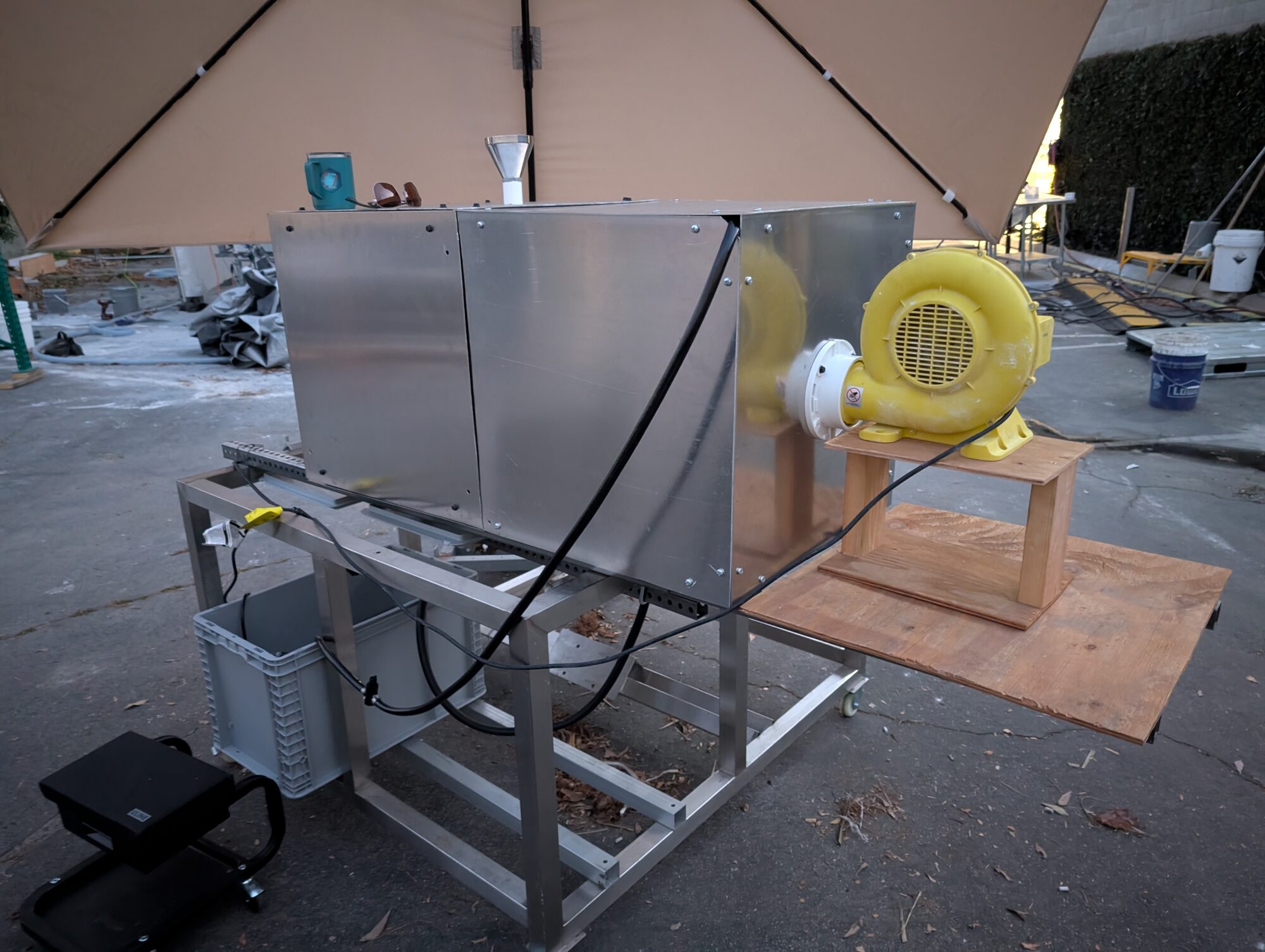 The skid set up outdoors under a canopy with the water tote on the shelf below